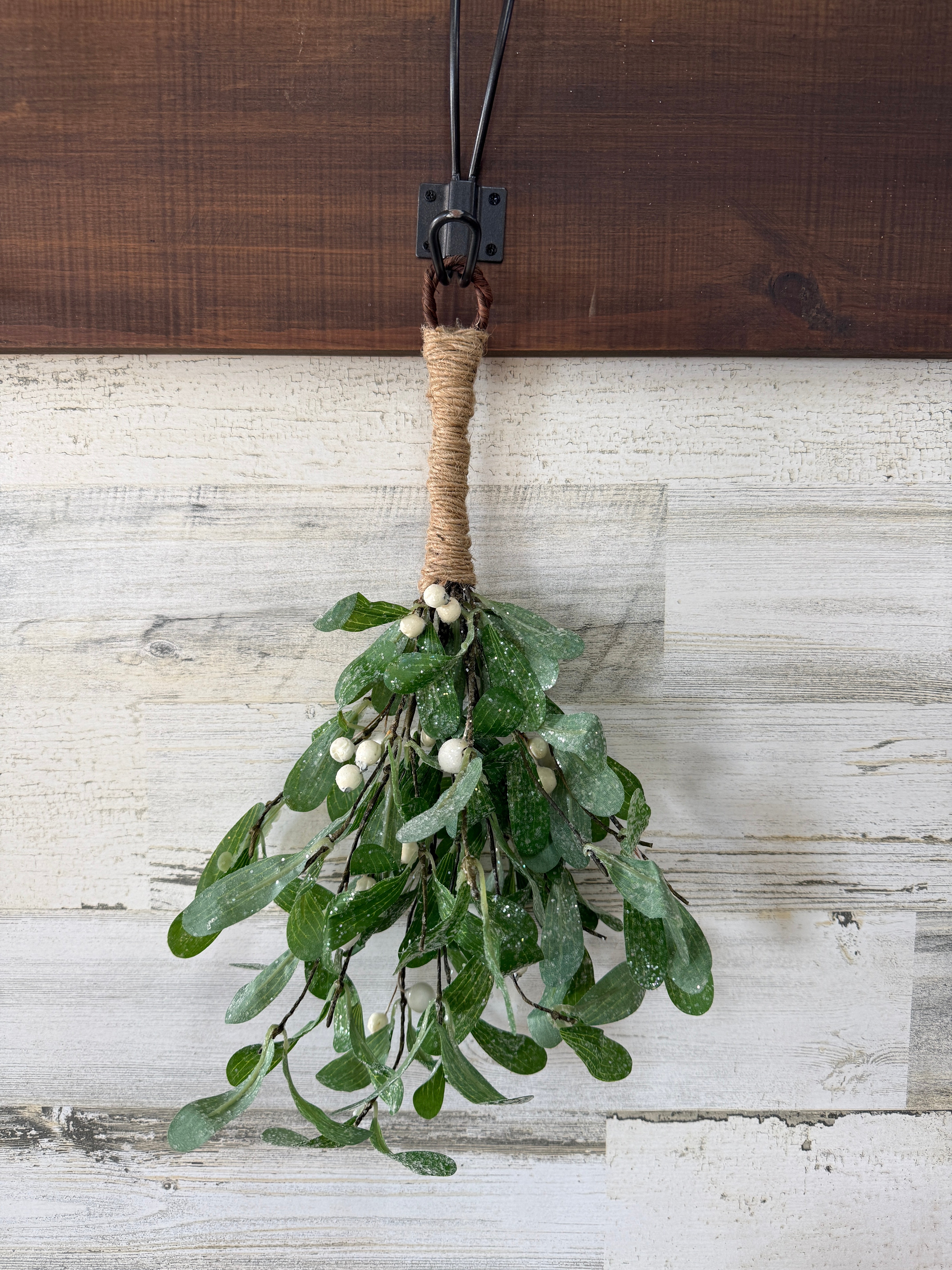 Bouquet of greenery tied with twine against a wooden background